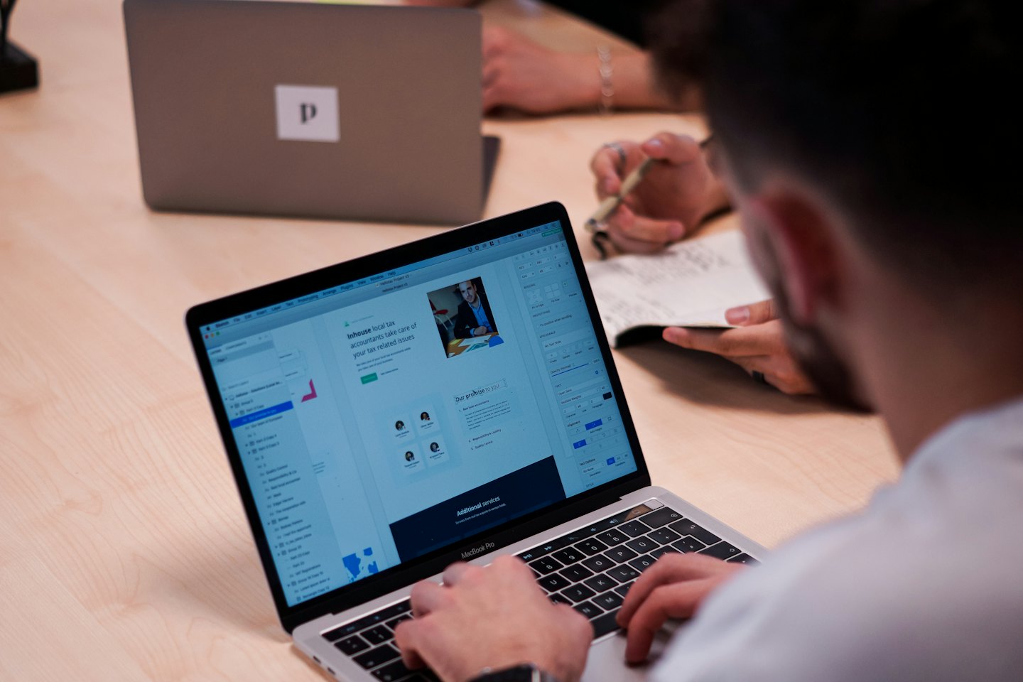 Handen typen op een laptop met websiteontwerp.